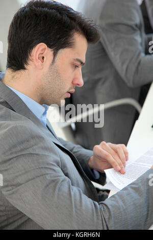 Jeune homme en remplissant le formulaire de demande Banque D'Images