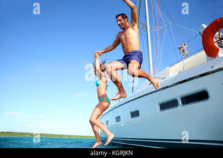 Jeune couple sauter dans l'eau à partir de la location Banque D'Images