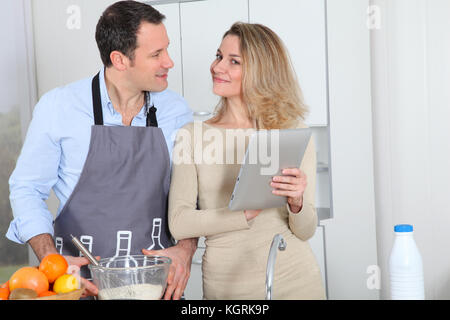 En couple à la recherche de recettes de cuisine à sur internet Banque D'Images
