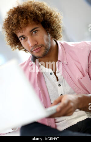 Handsome man in office working on laptop Banque D'Images
