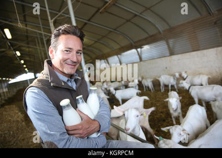 Smiling farmer holding bouteilles de lait Banque D'Images