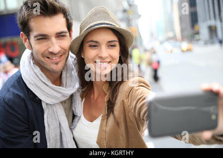 Couple dans Manhattan prenant photo with smartphone Banque D'Images