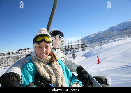 Couple assis sur le télésiège de ski Banque D'Images