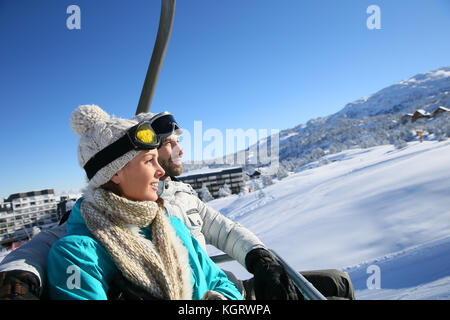 Couple assis sur le télésiège de ski Banque D'Images