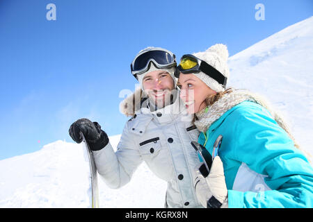 Cheerful couple de skieurs prêt à descendre la pente de ski Banque D'Images