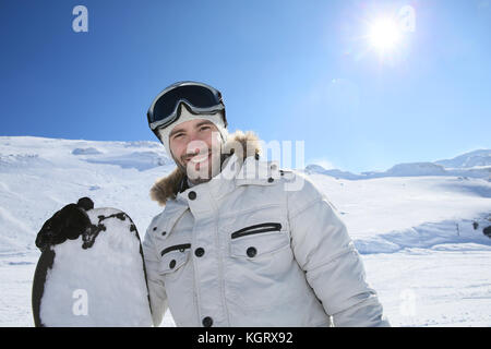 Portrait of cheerful snowboarder en haut de la pente de ski Banque D'Images