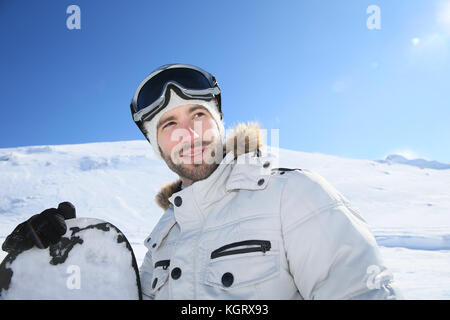 Portrait of cheerful snowboarder en haut de la pente de ski Banque D'Images