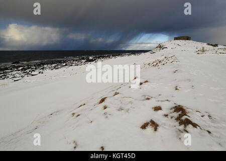 Ciel au-dessus de la tempête menaçante couvertes de neige et de galets, la plage de Boulders à eggum village de pêcheurs noircir les eaux de l'norskehavet-Norvège à la mer Banque D'Images