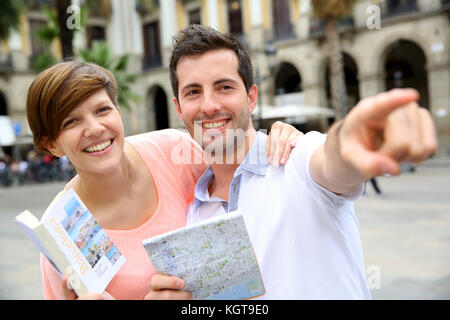 Les touristes dans la carte lecture Plaza Real de Barcelone Banque D'Images