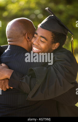 Père serrant son fils à son diplôme.