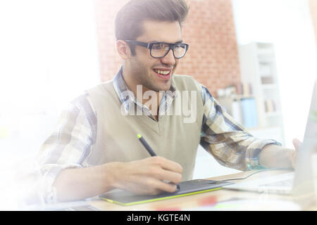 Jeune homme à l'aide de bureau tablette graphique Banque D'Images