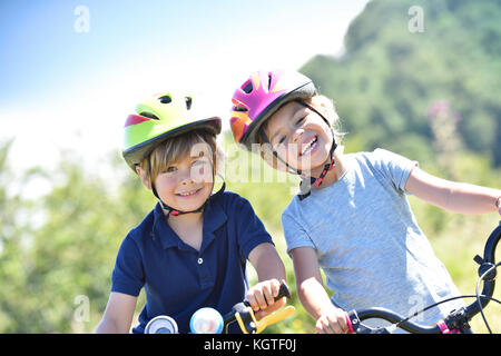 Portrait of happy kids riding bikes Banque D'Images