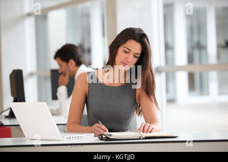 Attractive businesswoman working on laptop computer Banque D'Images