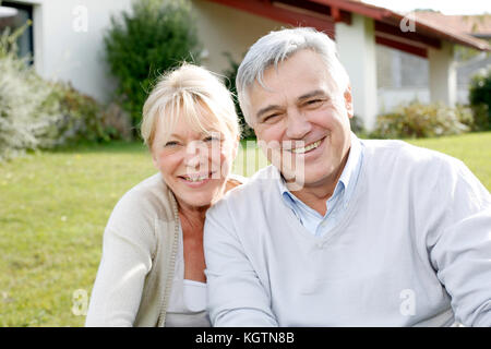 Smiling senior couple sitting in garden Banque D'Images