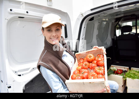 Cheerful agriculteur offrant des légumes frais Banque D'Images