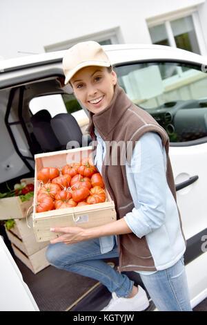 Cheerful agriculteur offrant des légumes frais Banque D'Images