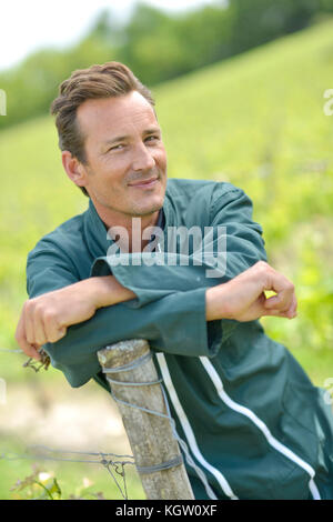 Smiling vigneron standing in vineyard Banque D'Images