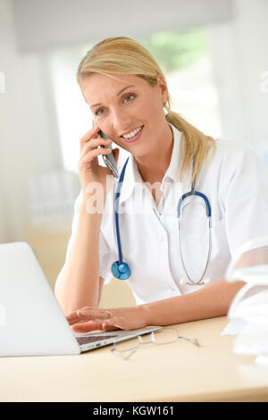 Portrait of doctor in office talking on phone Banque D'Images