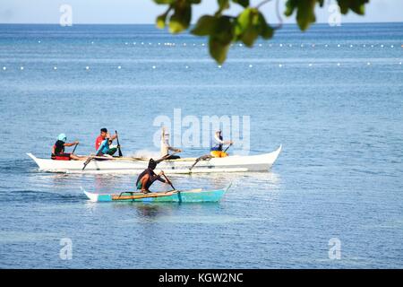 Pêcheurs philippins qui naviguent sur le bateau de pêche traditionnel en bois appelé Bangka ou Banca à l'île de Siquijor, Philippines Banque D'Images