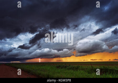 La foudre illumine un nuage de mur dans un orage supercellulaire au coucher du soleil Banque D'Images