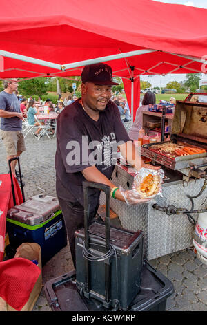 Fier tenant un grand vendeur de hotdog hotdog avec tous les extras lors d'une foire de rue montrant sa délicieuse dans Montgomery, en Alabama, USA. Banque D'Images