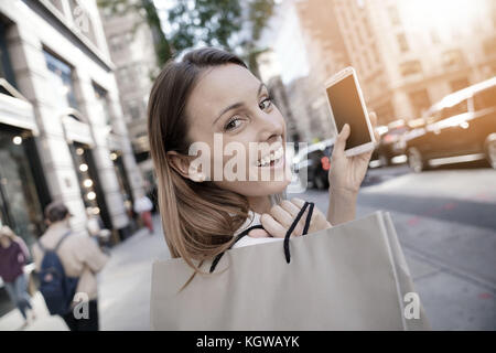 Cheerful girl shopping à Manhattan et parlant au téléphone Banque D'Images