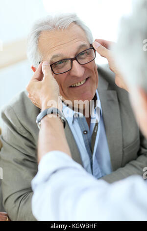 Hauts homme essayant de nouvelles lunettes, magasin optique sur Banque D'Images