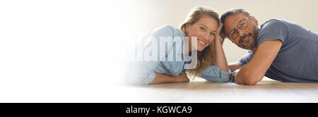 Mature couple laying on floor and looking at camera Banque D'Images