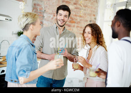 Joyeux amis interculturel se sont réunis le vendredi soir à la maison de l'un d'eux Banque D'Images