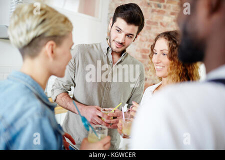 Les jeunes couples sympa de prendre un verre tout en ayant une conversation à la maison partie Banque D'Images