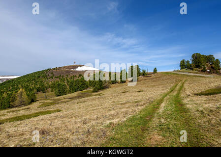 Vue panoramique avec tour de télécommunication au sommet d'une montagne, route et arbres contre un ciel bleu sur une journée ensoleillée Banque D'Images