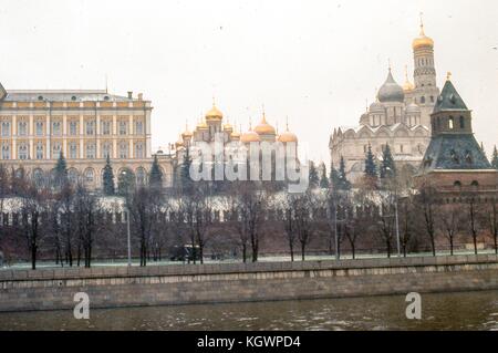 Vue orientée au nord du mur sud du complexe immobilier du Kremlin, prise depuis le quai Sofiyskaya situé de l'autre côté de la rivière Moscou, novembre 1973. En arrière-plan, plusieurs points de repère sont visibles de gauche à droite : le Grand Palais du Kremlin, la Cathédrale de l'Annonciation, la Cathédrale de la Dormition et le Grand Campanile Ivan. Au premier plan le long du mur extérieur se trouve la tour Taynitskaya. Banque D'Images