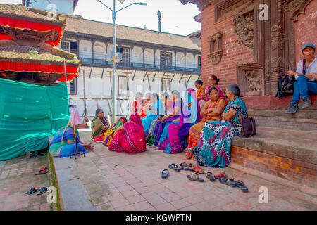 Katmandou, Népal, 15 octobre 2017 : Groupe non identifié de la femme assise dans le sol à l'extérieur avec quelques bâtiments de la reconstruction après le séisme, en 2015, de durbar square de Katmandou, capitale du Népal Banque D'Images