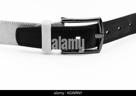 Ceinture en cuir noir est insérée dans la boucle de la ceinture blanche sur fond clair Banque D'Images