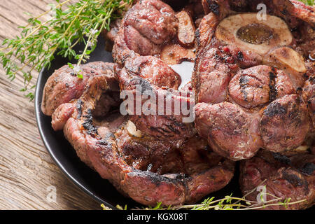 Osso Buco de porc rôti au thym frais sur un fond de bois Banque D'Images