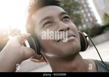 Portrait of smiling handsome asian guy avec le casque Banque D'Images