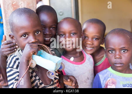 Un groupe d'enfants, rire, gesticulant, s'amusant posant devant la caméra. L'un d'eux est maintenant une simple petite voiture faite d'une bouteille et de bo Banque D'Images