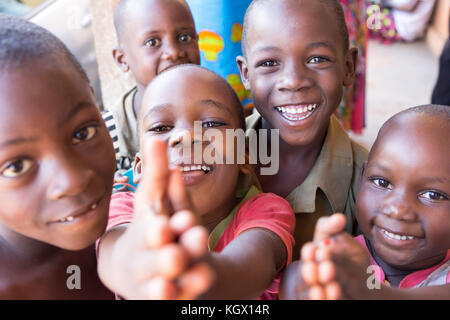 Une bande d'enfants ougandais au hasard dans la rue en riant, souriant, agitant et avoir du plaisir devant la caméra. Banque D'Images