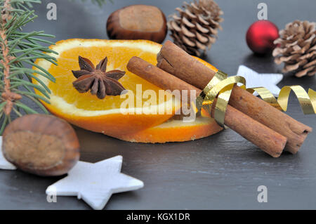 Bâton de cannelle en ruban doré sur tranche d'orange Banque D'Images