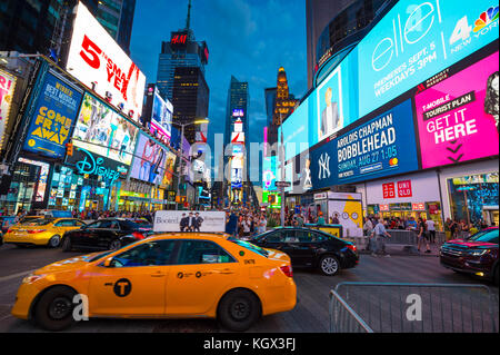 NEW YORK - 23 AOÛT 2017 : des panneaux lumineux clignotent au-dessus de la foule des fêtes et de la circulation qui passe devant Times Square pour la Saint-Sylvestre Banque D'Images