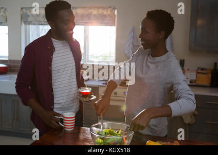 Heureux couple preparing salad dans la cuisine Banque D'Images