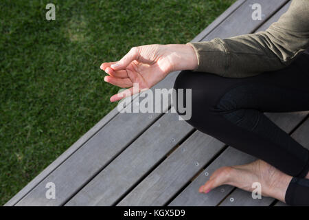 La section basse de woman practicing yoga in porche sur une journée ensoleillée Banque D'Images