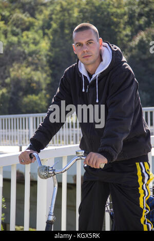 Un jeune homme, gopnik, assis sur un vélo Banque D'Images