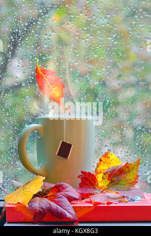 Fenêtre des pluies d'automne avec du thé chaud et des livres Banque D'Images