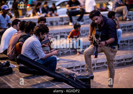 De jeunes jouant de la musique dans la soirée à un lieu de rassemblement à Mumbai, Inde Banque D'Images