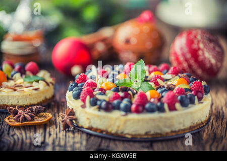 Cheescake avec baies de fruits frais fraises framboises et anis étoilé. Cheescake de Noël avec décoration de noël. Banque D'Images