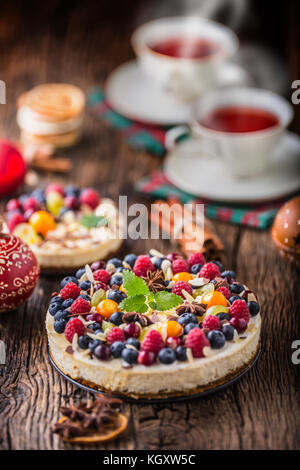 Cheescake avec baies de fruits frais fraises framboises et anis étoilé. Cheescake de Noël avec décoration de noël. Banque D'Images