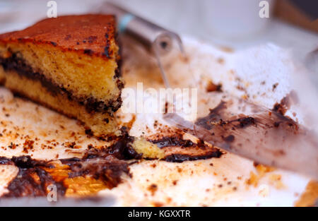 Close up de restes de gâteau avec la crème au chocolat et miettes avec une pelle transparent Banque D'Images