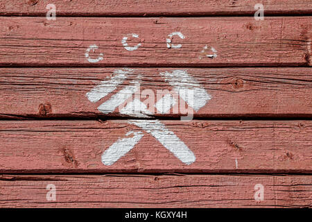 Lettres cccp (fédération en abrégé pour l'Urss) et d'un croisement de marteau et clé anglaise, un symbole communiste, peint en blanc sur rouge, érodés, surface en bois Banque D'Images