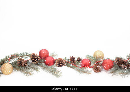 Christmast avec décoration de branches de sapin, de cônes, de boules et guirlandes sur une vraie neige Banque D'Images